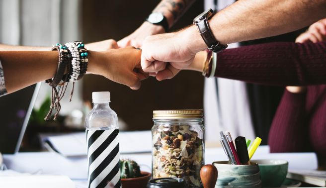 Three colleagues team fist bump
