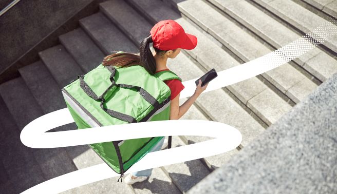 Female deliveroo driver on a mobile phone for the Valamis Belgian social balance sheet blog