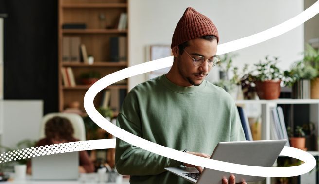 Man in a home setting with laptop - image for Valamis training evaluation template download guide