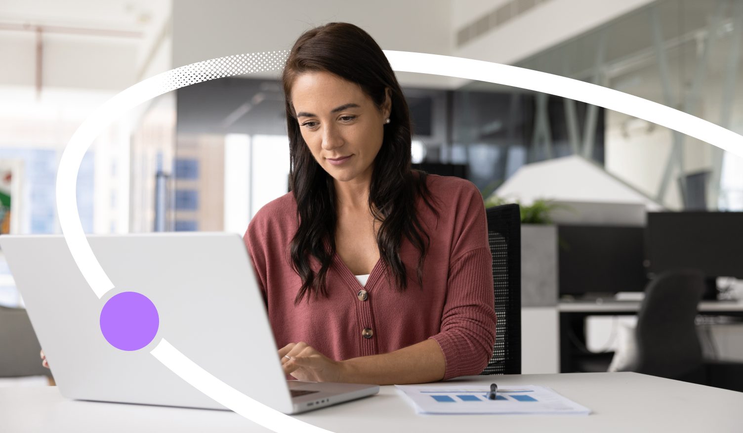 Woman reviewing training data on her laptop with a printed chart beside her